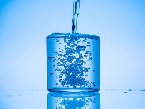 blue water being poured into a blue cup against a blue background